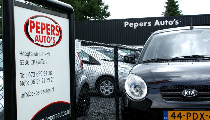 Informatiebord van Pepers Auto's bij de ingang